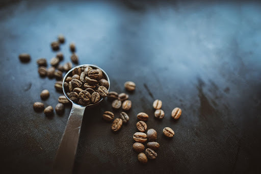 Coffee beans in a measuring spoon.