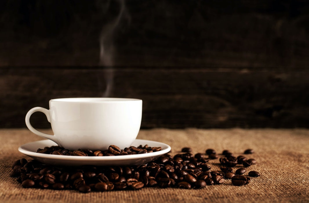 Cup of coffee on top of coffee beans