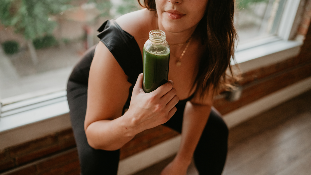 Green powder drink in a water bottle held by an athlete.