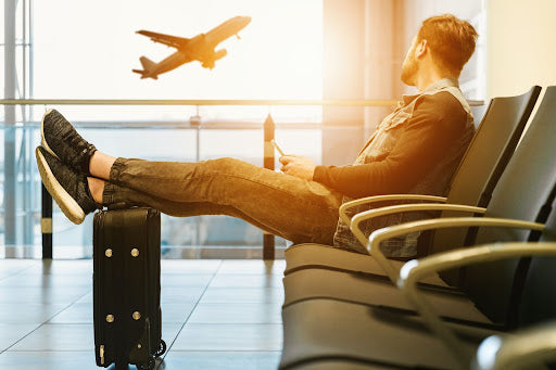 Man watching plane takeoff through a window.